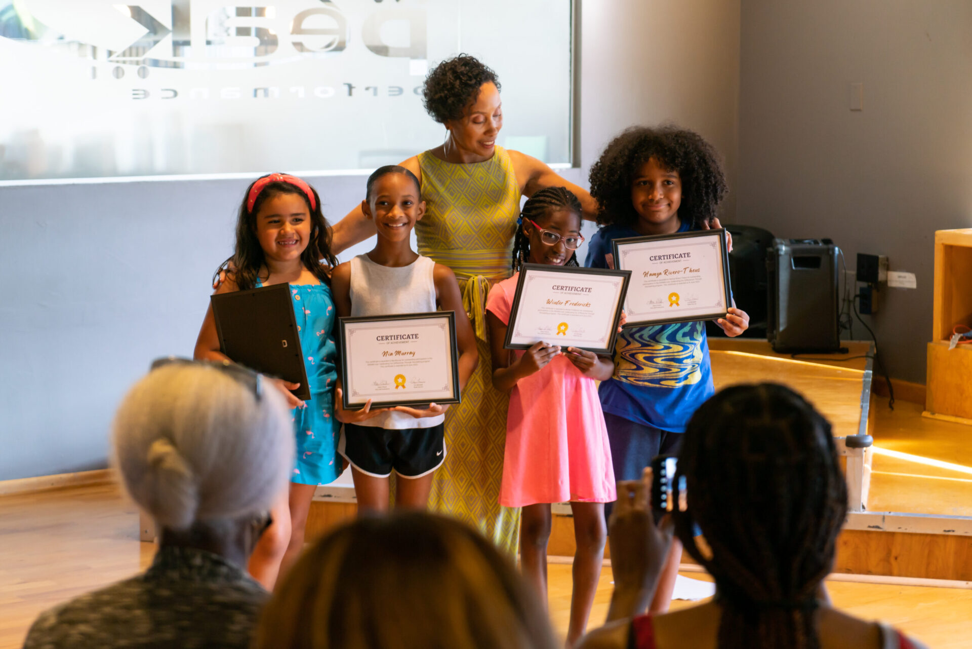 A group of girls holding up their certificates.